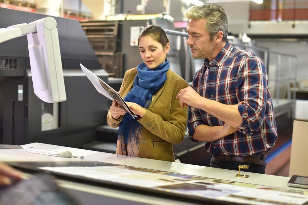Man in printing house showing client printed documents.jpeg
